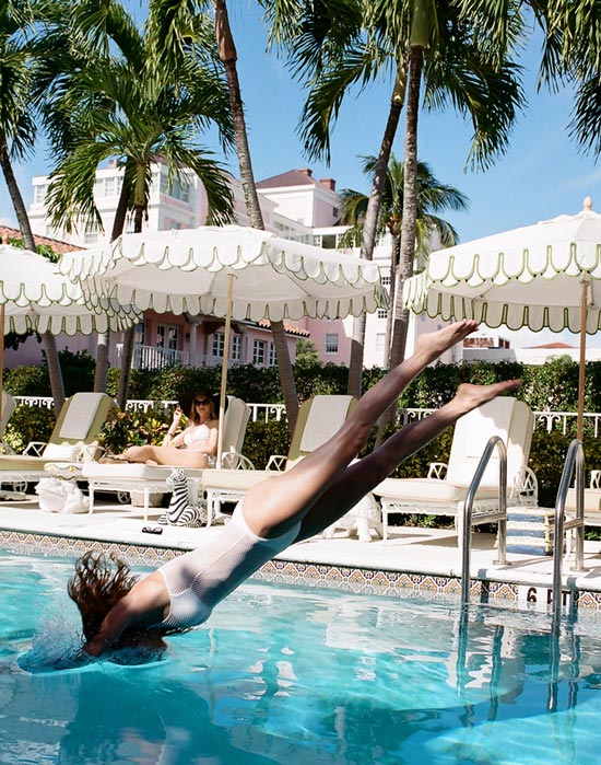 woman jumping into swimming pool
