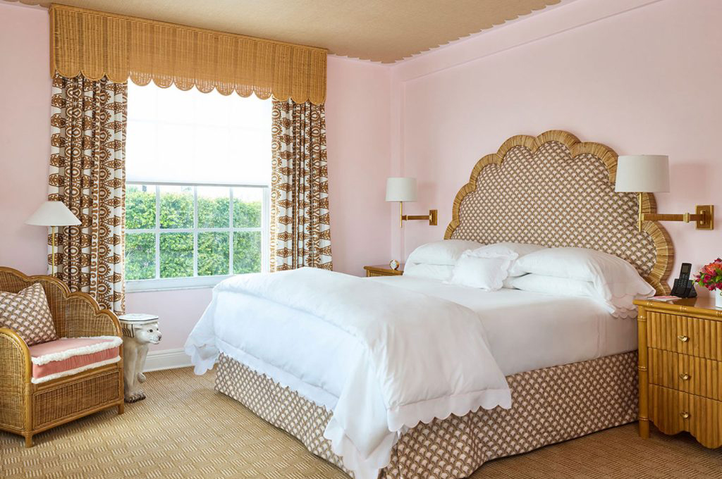 guest room with pink walls, bed and desk