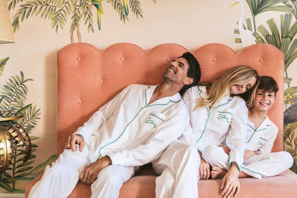 couple in pajamas lounging on pink sofa