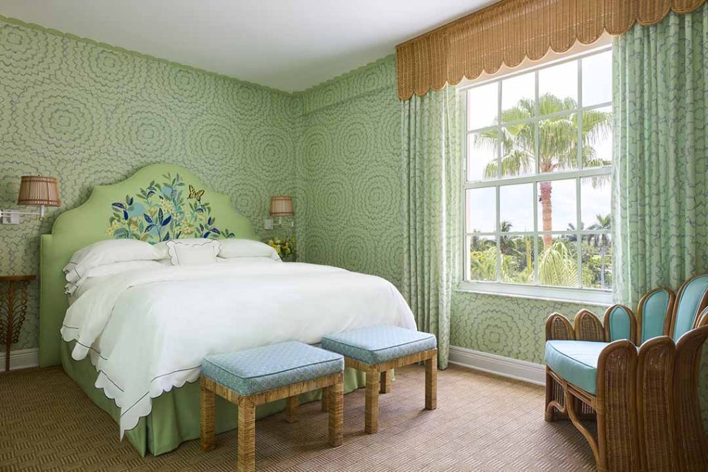 green guest room with king bed and furniture