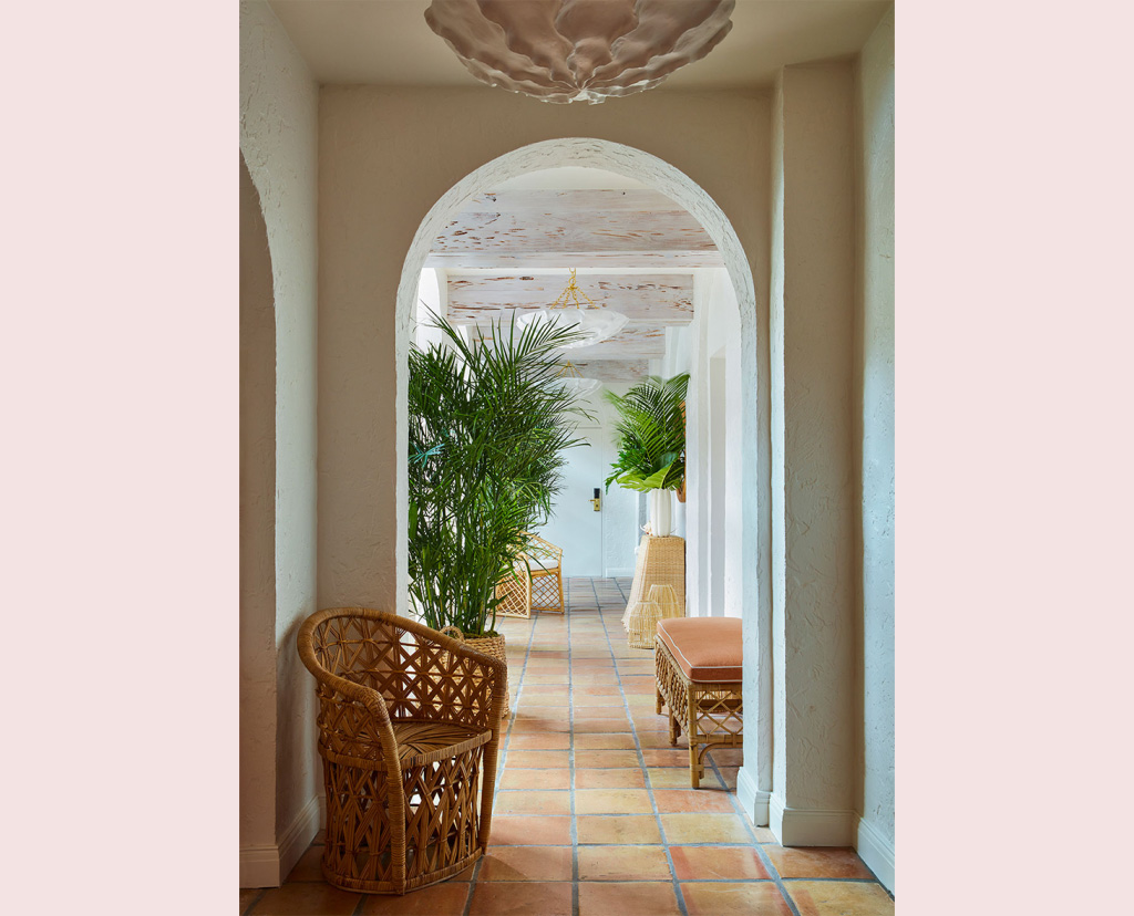 rattan chair in hallway with arched door