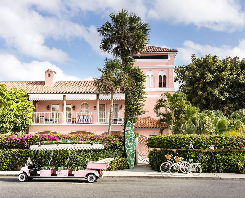 Hotel exterior with pink golf cart in front.