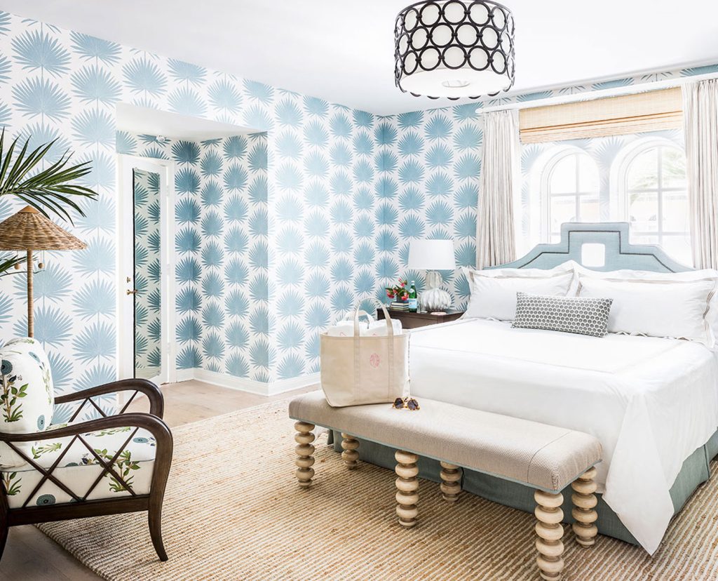 Light and airy bedroom with blue palm wallpaper.