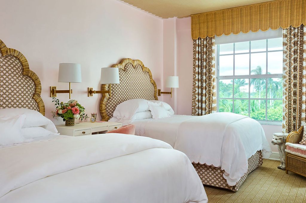 pink guest room with golden headboards