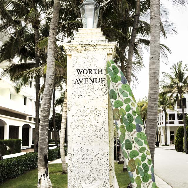 surfboard leaning on worth avenue sign